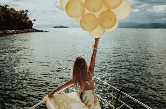 woman with balloons on boat - freedom